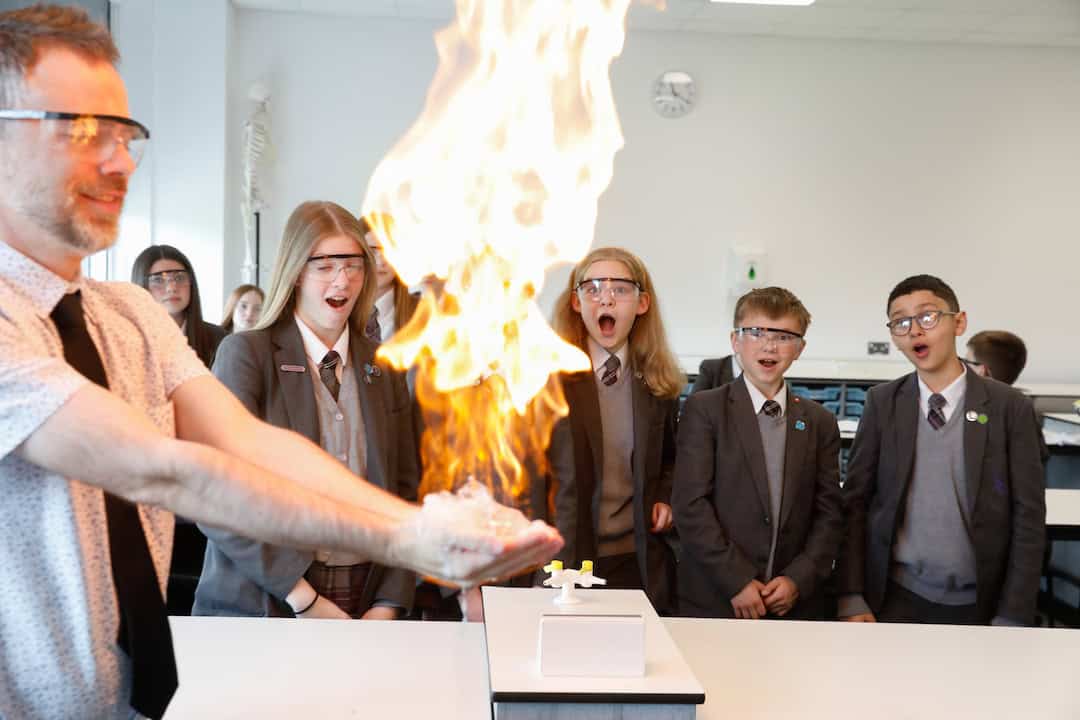 Laurus Cheadle Hulme students watch a science experiment with big flame.