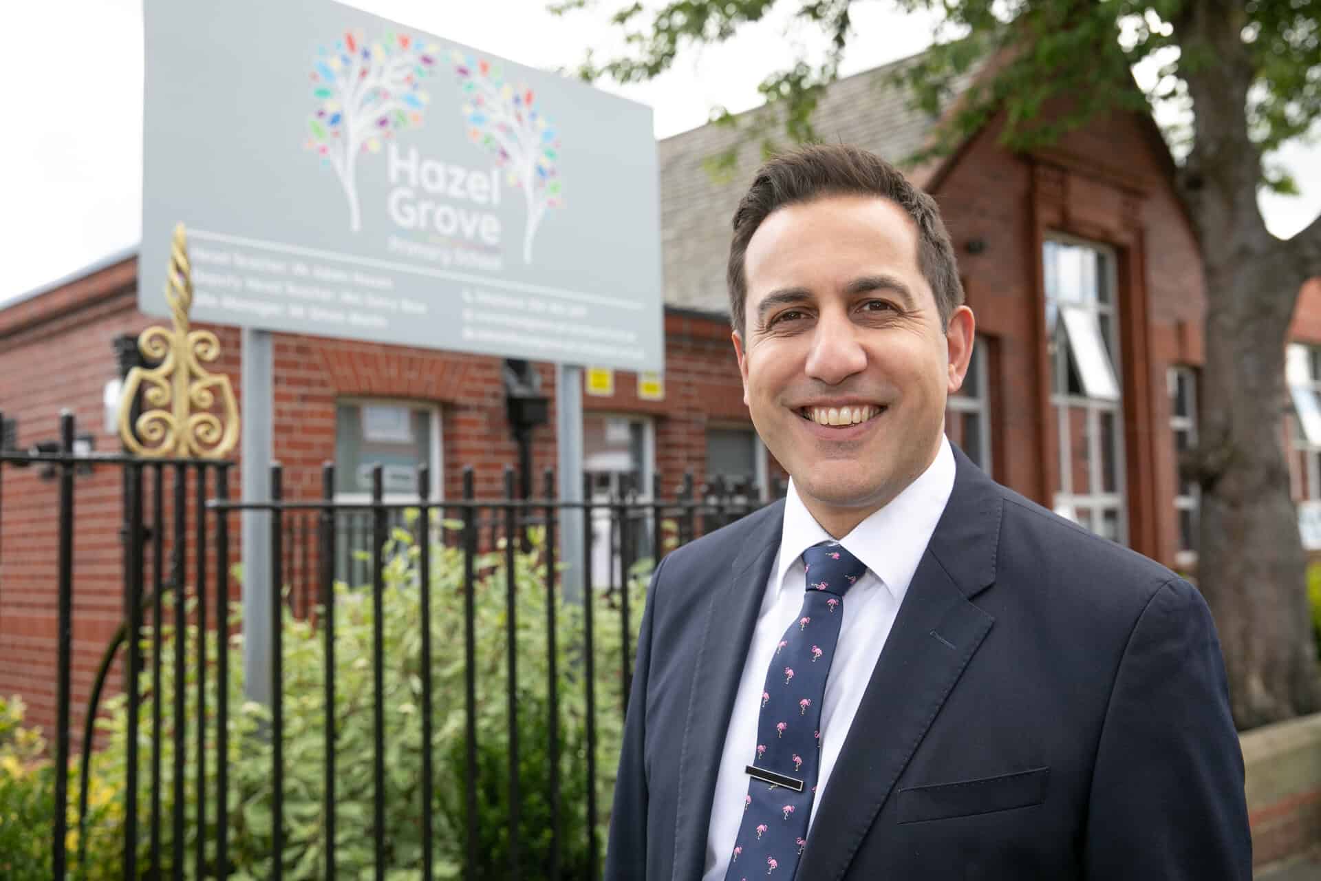 Image of Adam Hossen stood outside Hazel Grove Primary School.